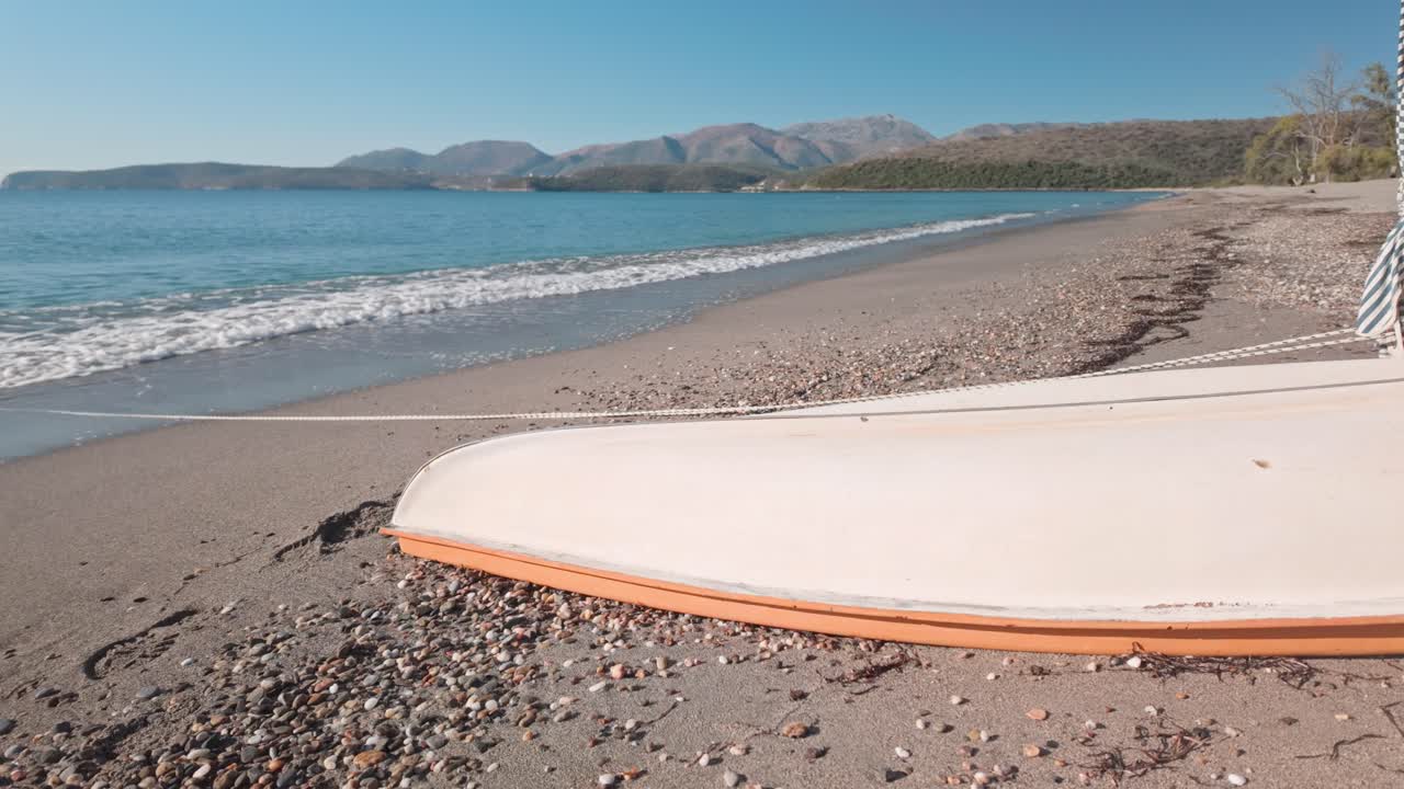 Upturned leisure boat on sunny sandy Mediterranean deserted beach