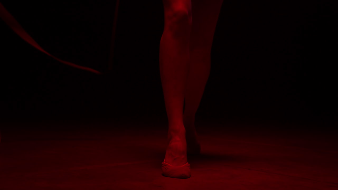 mujer con piernas delgadas haciendo gimnasia rítmica en el interior. gimnasta femenina actuando.