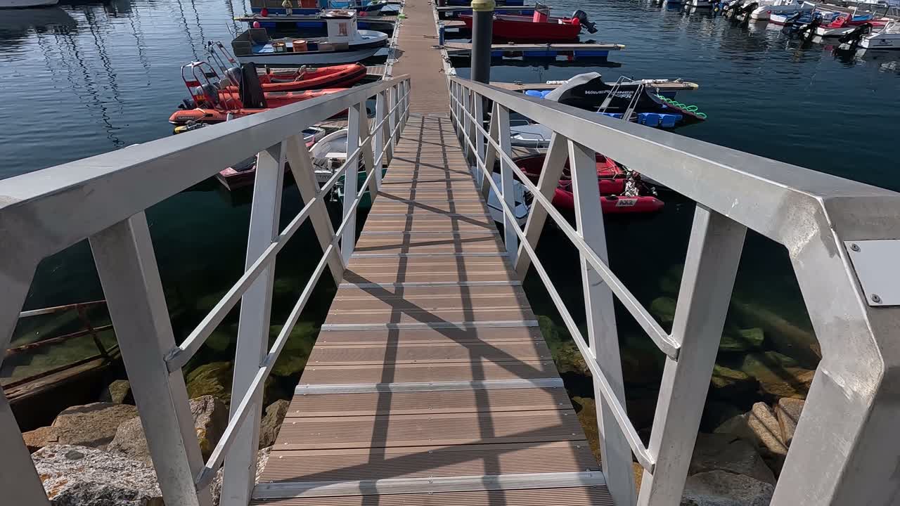 rampa de acceso al muelle de la marina con barcos de recreo de pie con la calma del mar en un día de verano antes de la llegada de los turistas, señal de tiro hacia arriba