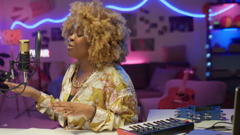 woman singing into microphone in a home recording studio