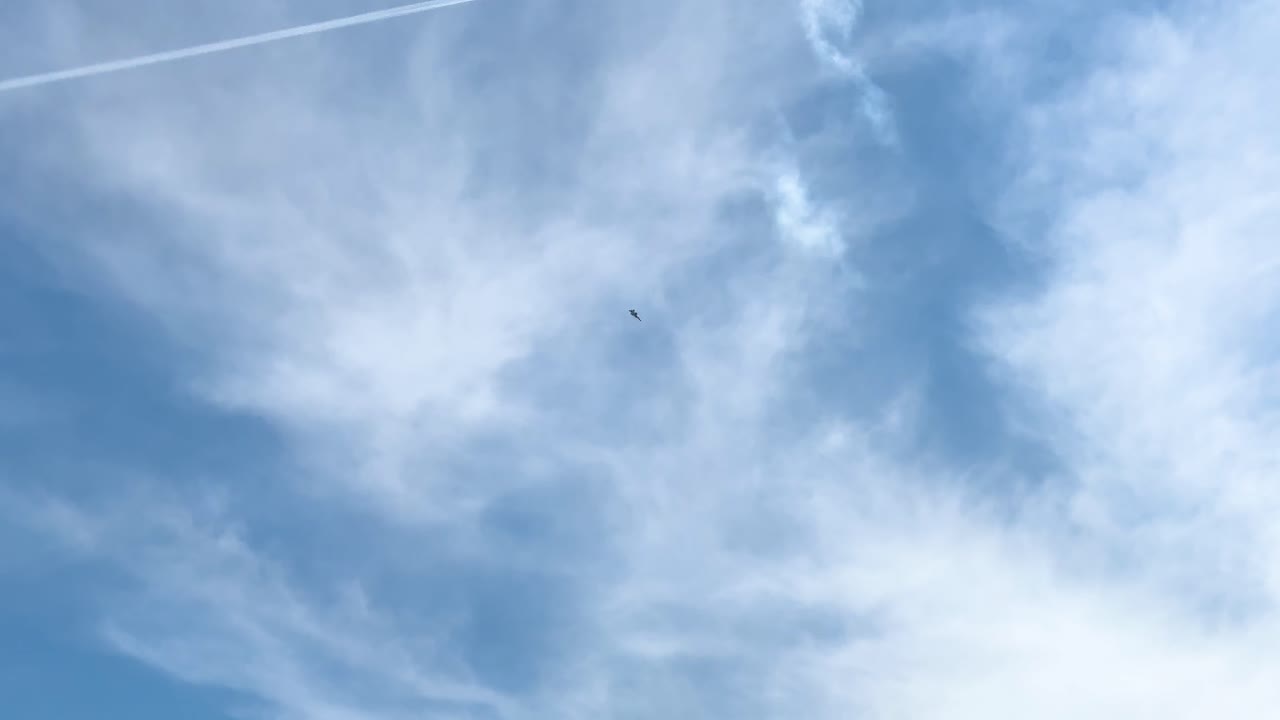 A jet flies through a partly cloudy sky, leaving a contrail. Captured at an airshow in Geelong, Australia