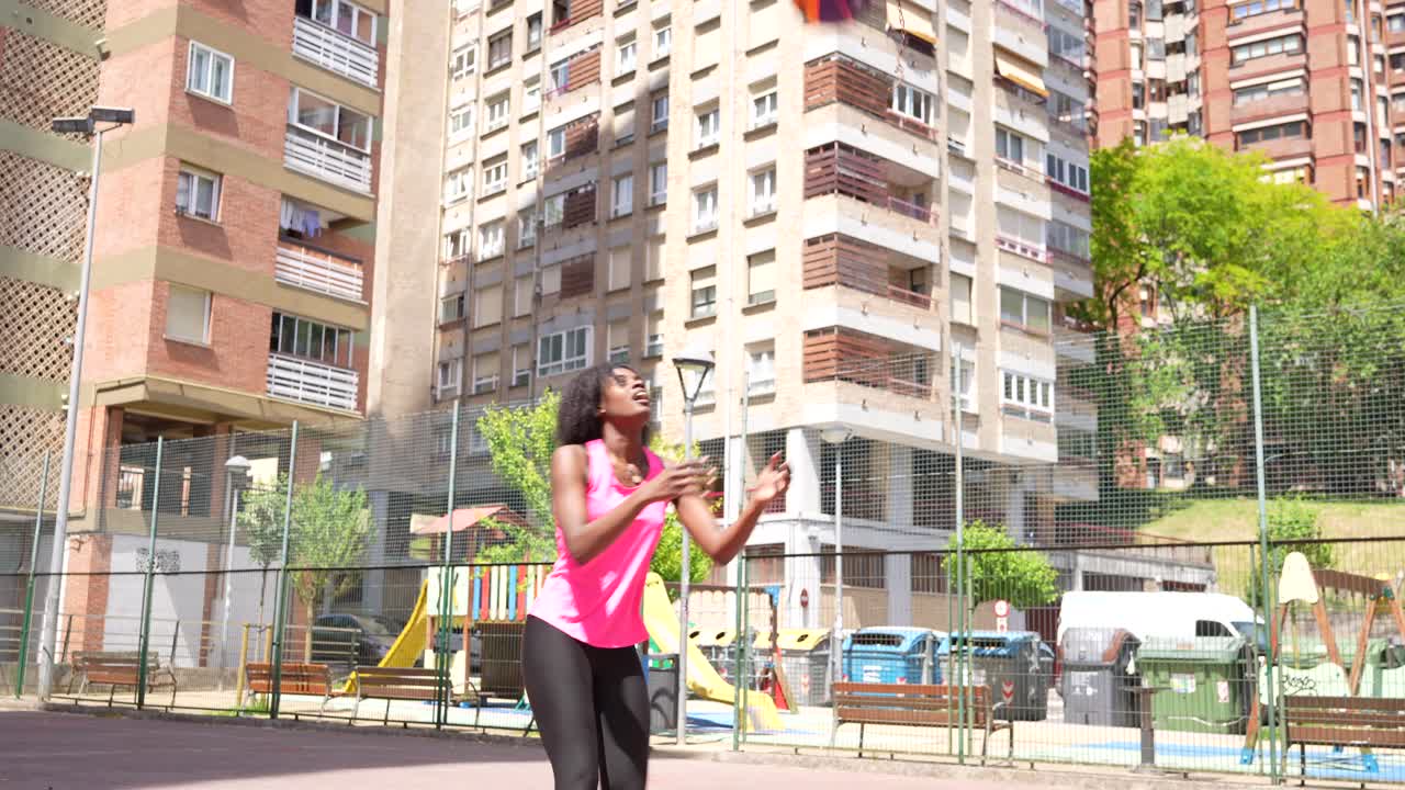 Woman playing basketball in urban setting
