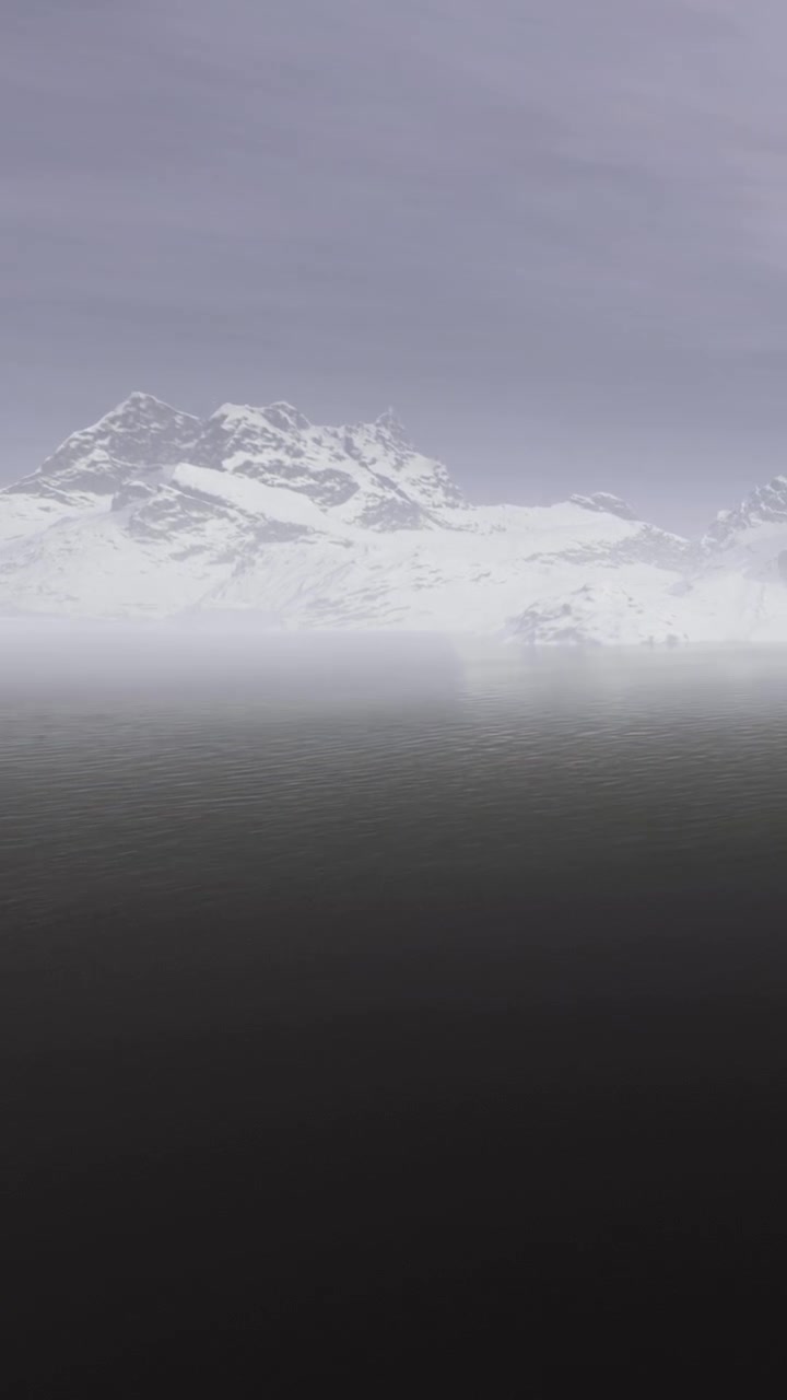 Mountains and water seen at dusk with mist in the sky above the lake