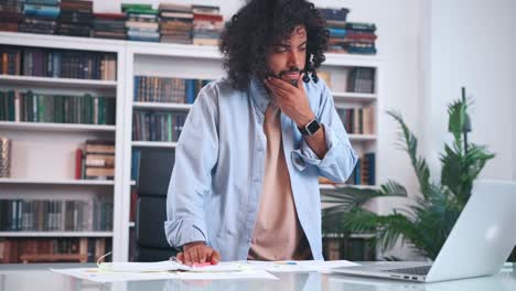 carried away arabian man standing working with laptop and making entries