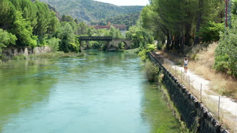 Young-woman-walking-her-pet-dog-along-the-footpaths-of-Lago-de-Bolarque