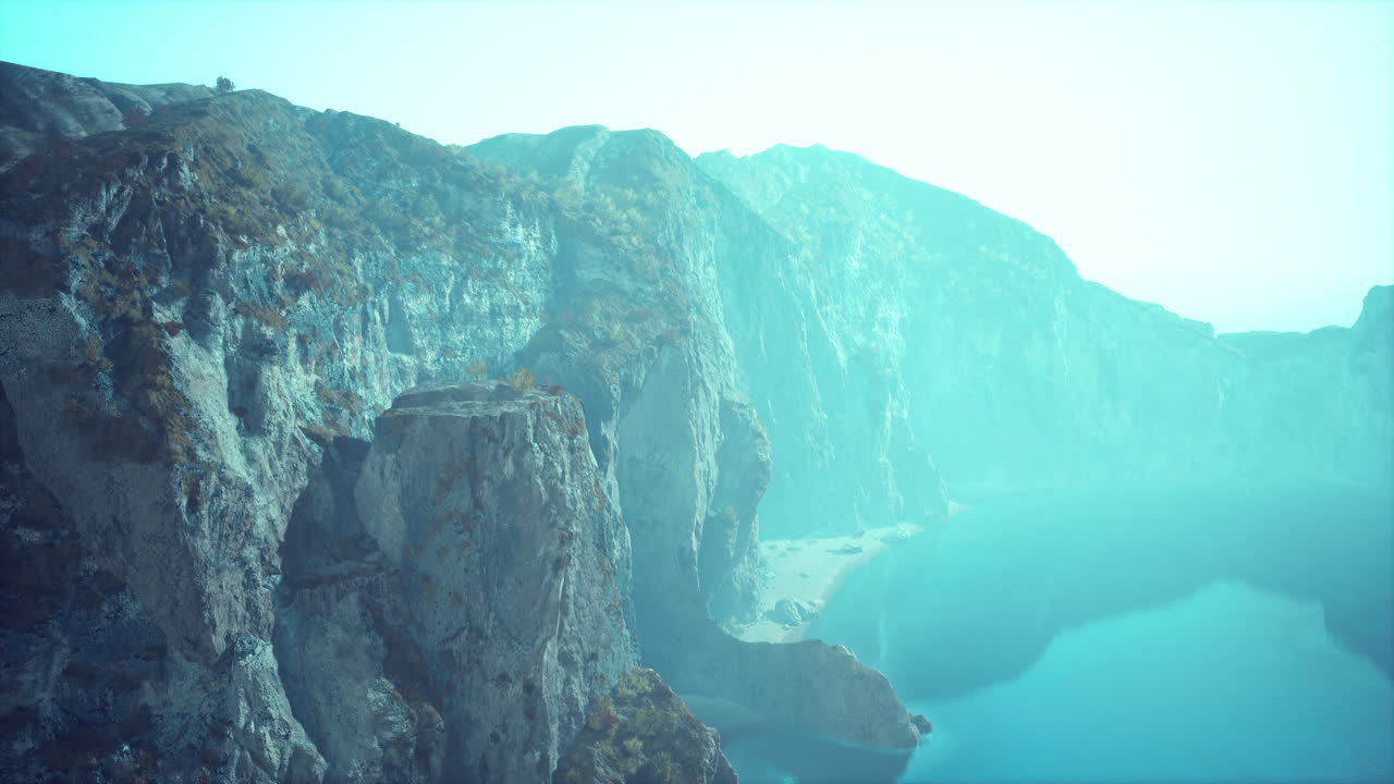 산 과 절벽 으로 둘러싸인 호수 의 경치 가 아름답고, 공기 에 안개 가 있다