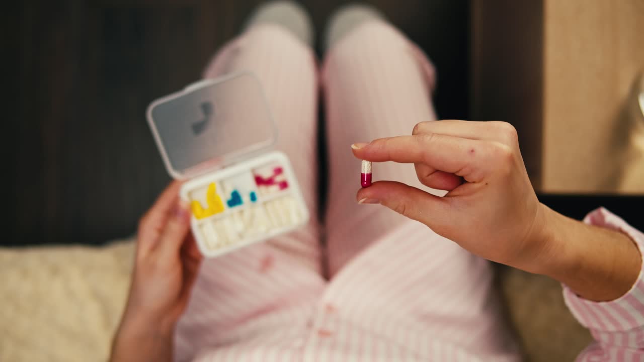 잠옷을 입고 약을 먹는 여자