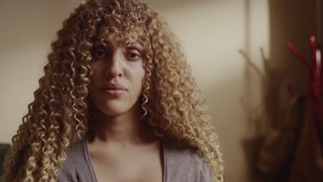 close-up portrait of a young woman with long, curly blonde hair