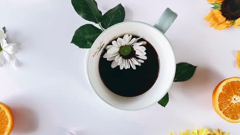 a cup of coffee with flowers and oranges