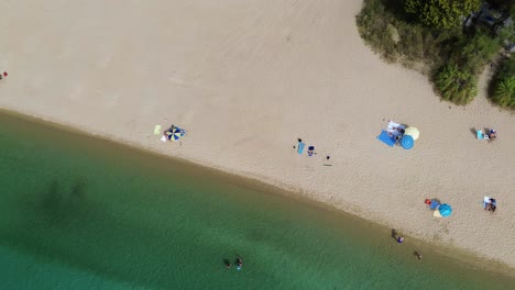 From-sea-to-sandy-beach-Kalogria-Beach-Aerial-View-of-sandy-paralia-Kalogria-close-to-Nikiti-and-Elia-Nikitis-in-Halkidiki,-Greece