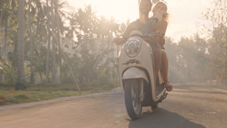 coppia di viaggiatori in motocicletta su un'isola tropicale che esplora una bellissima destinazione di viaggio divertendosi su uno scooter