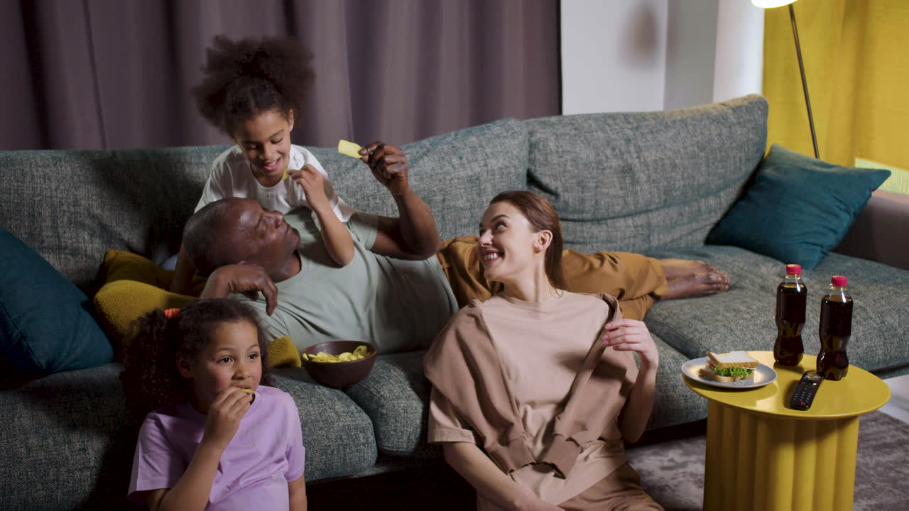niños con padres viendo películas en casa