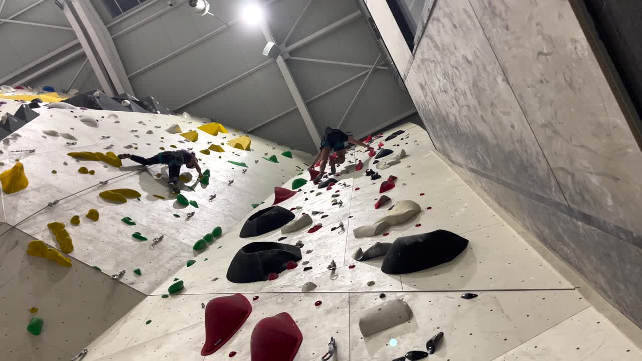People Climbing an Impossible Wall Inside a Gym