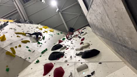 people climbing an impossible wall inside a gym