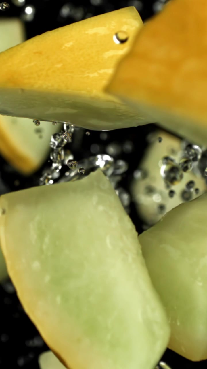 Fresh Melon Pieces Falling and Splashing in Water