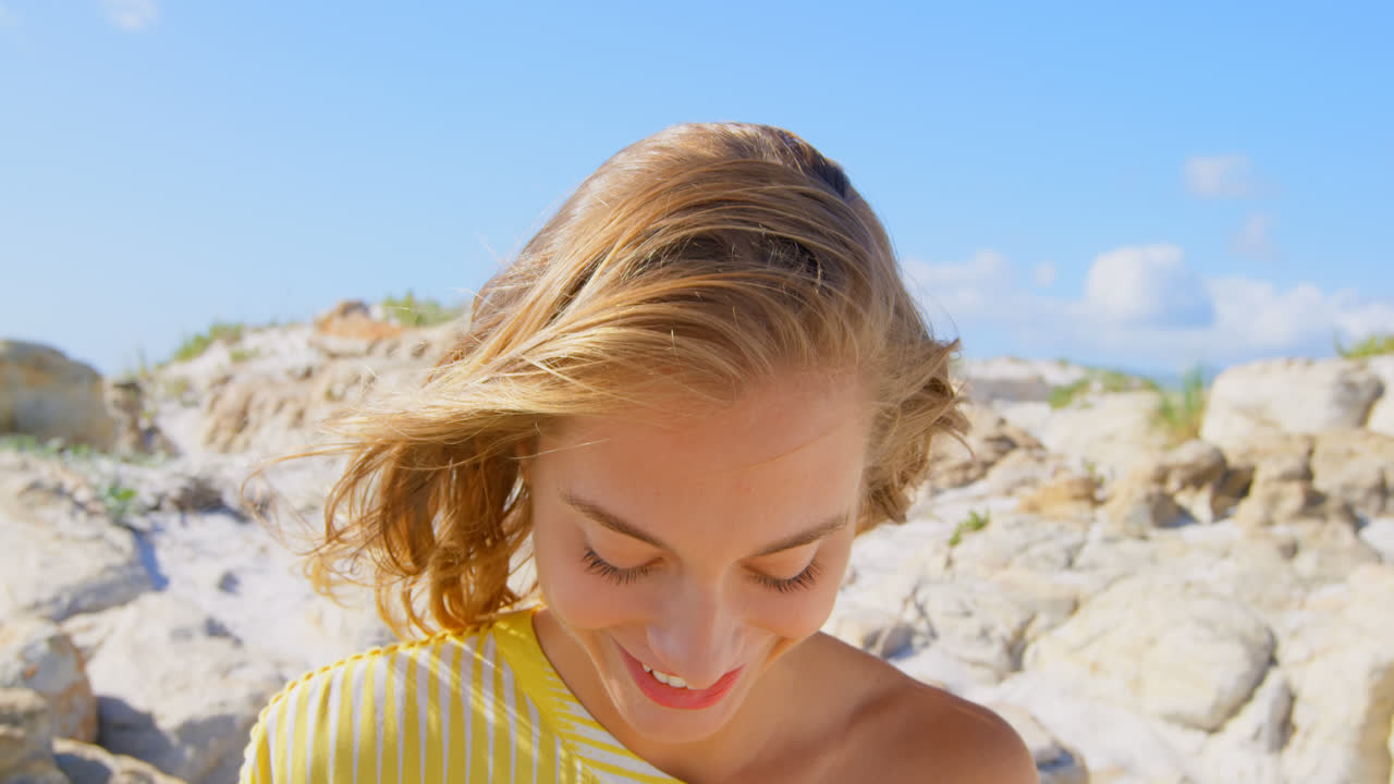 Vista frontale di giovane donna caucasica in piedi sulla spiaggia 4k