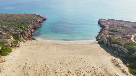 Turquoise-Water-Of-Calamosche-Beach-In-Vendicari-Natural-Reserve-In-Sicily,-Italy---aerial-pullback