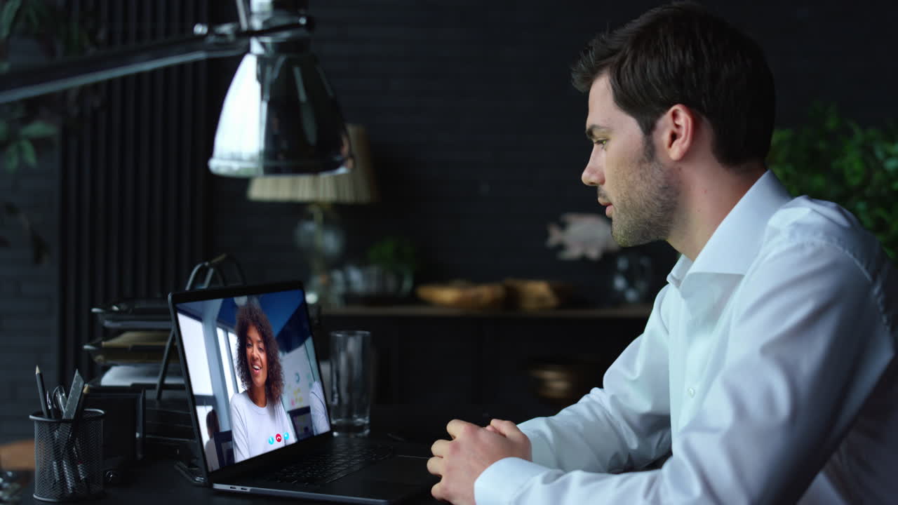 Manager talking online interview looking laptop web camera in office close up