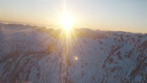 flying through a cold snowy mountain side of canada, bc at sunset