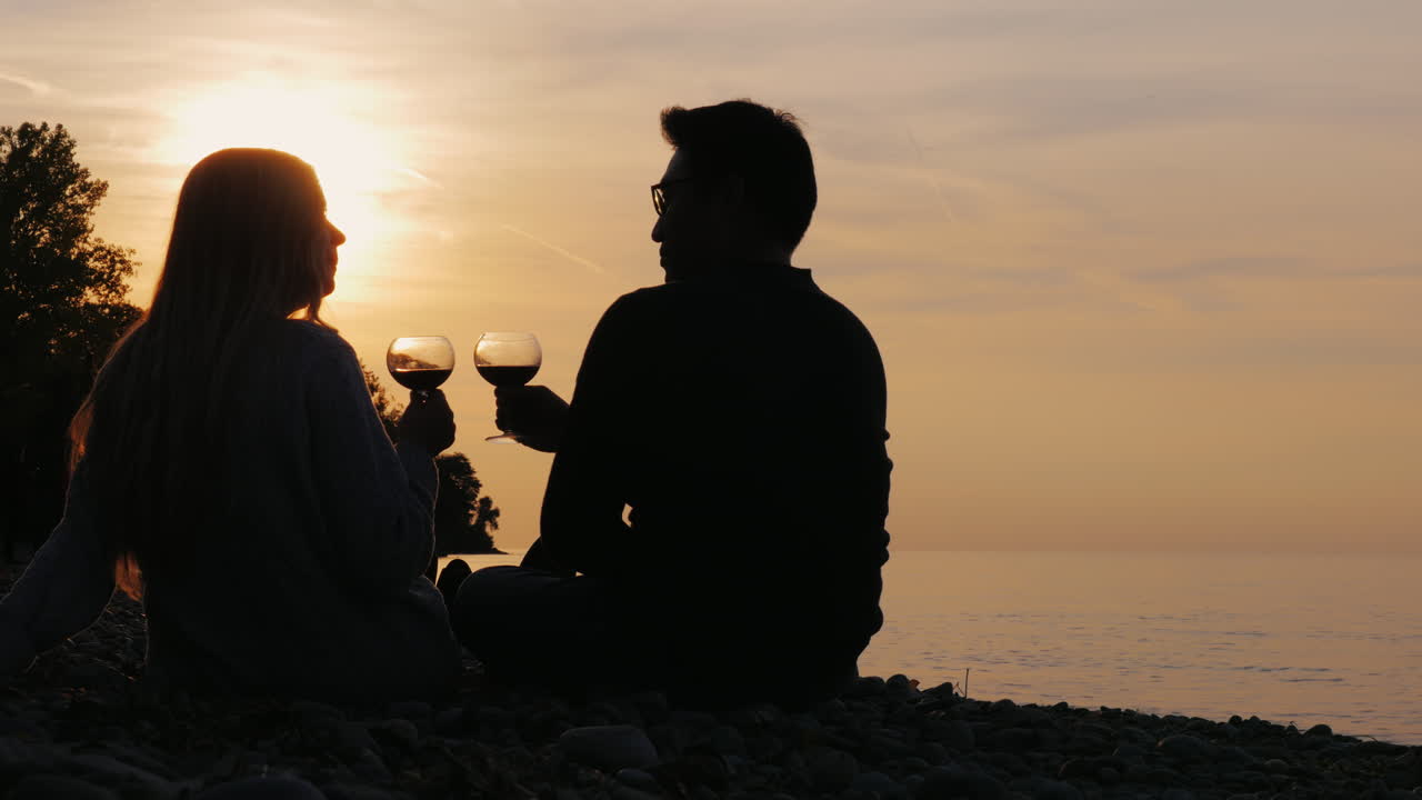 호수 3에서 석양에 와인을 마시는 젊은 부부의 실루엣