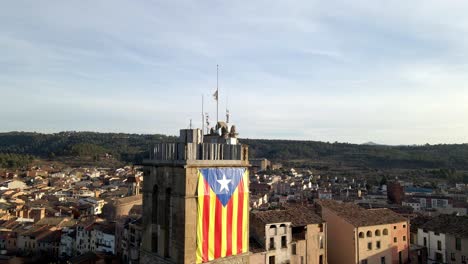 descending aerial shot of a tower with a catalunya flag