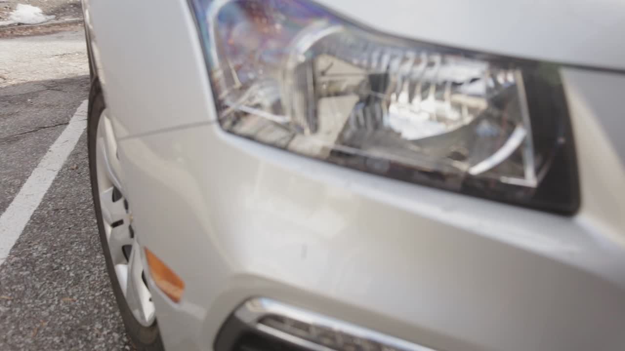 White Car Parking At The Roadside With Its Right Headlight Blinking Twice - Close Up Shot