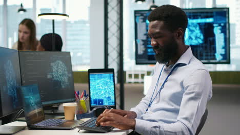 system administrator at office desk develops software using ai, listening music