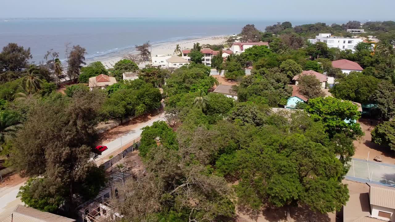 Kinoreifer Panorama-Drohnenblick auf den Stadteingang von Banjul vom Arch 22 mit Blick auf den Atlantischen Ozean an einem sonnigen Tag in Westafrika.
