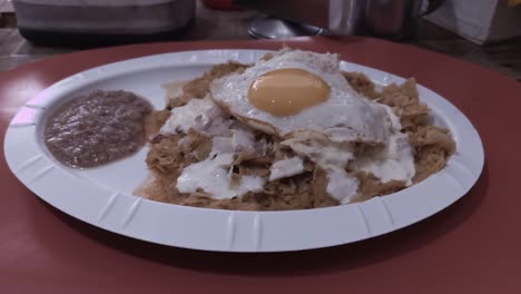 green chilaquiles on a plate with scrambled eggs