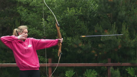 blonde woman shooting bow and arrow in cinemagraph