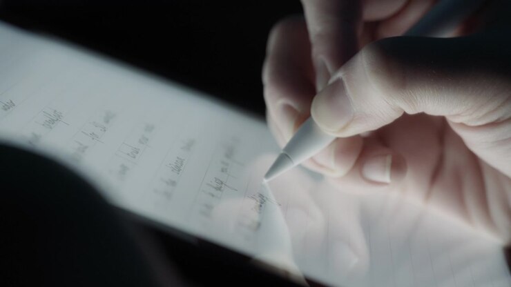 Persona che scrive una lista di attività su un tablet usando una penna.