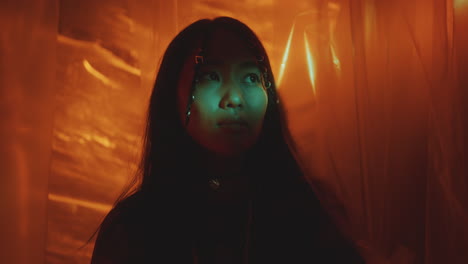 dreamy asian woman in dark studio with plastic wrap background
