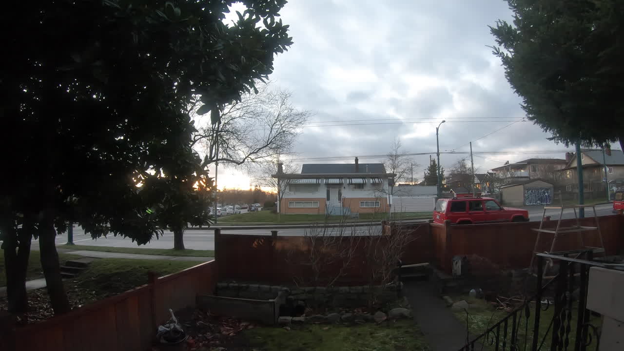 일몰 전에 거리를 지나가는 차량의 집 밖에서 보기