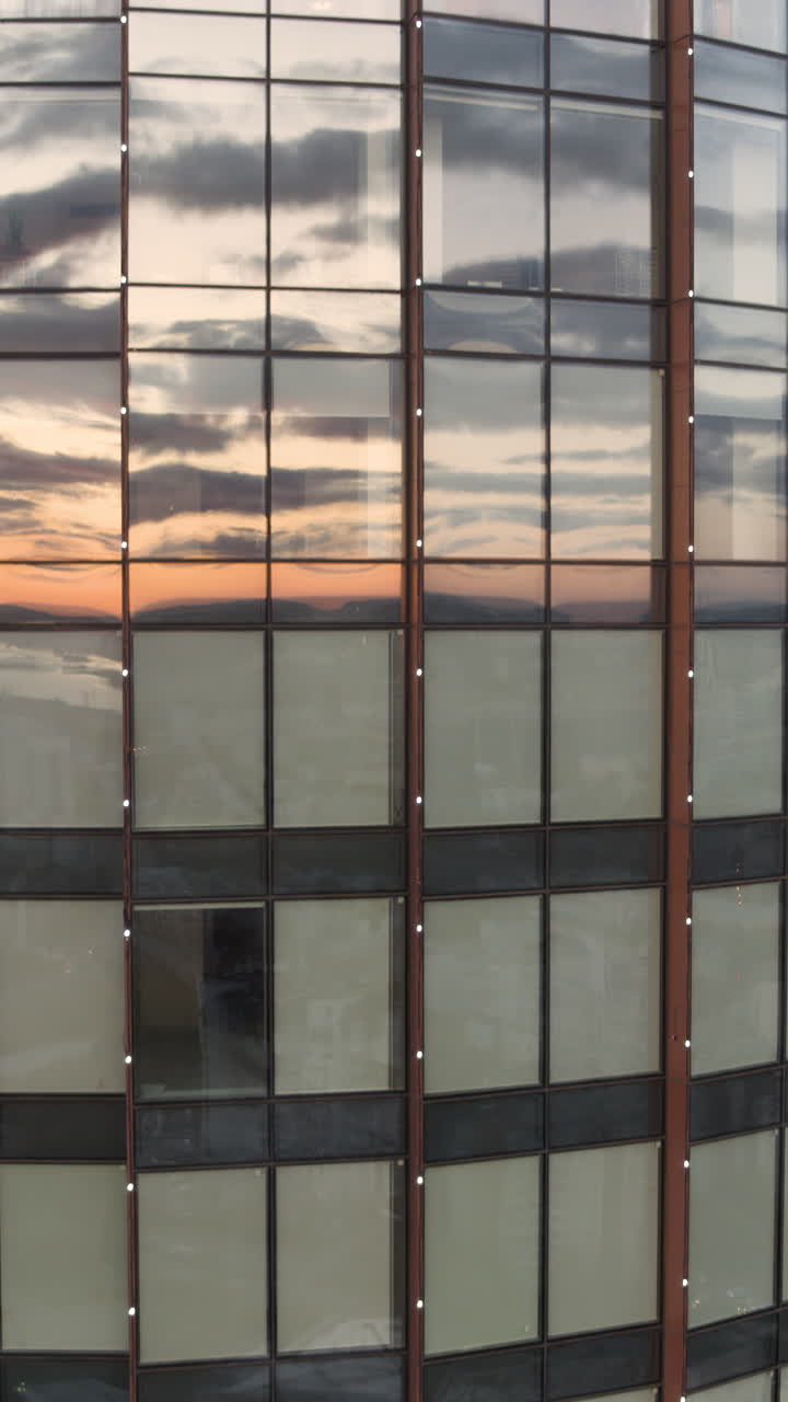 fachada de edificio moderno con reflejos del atardecer