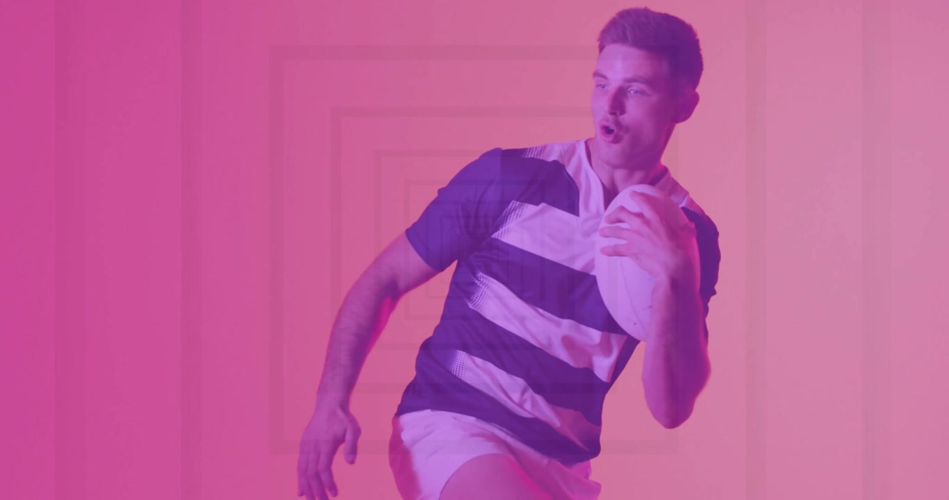 Male athlete taking forward step, manipulating rugby ball in pink-purple studio for sports training