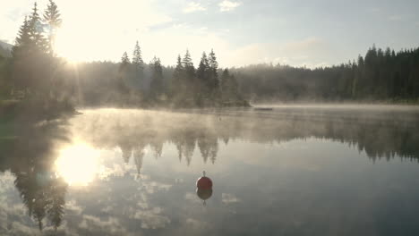 beautiful sunrise shining over the lake caumasee and forest near the flims in grisons, switzerland