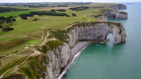 flying high above the rocky arch of etretat on the coast of france