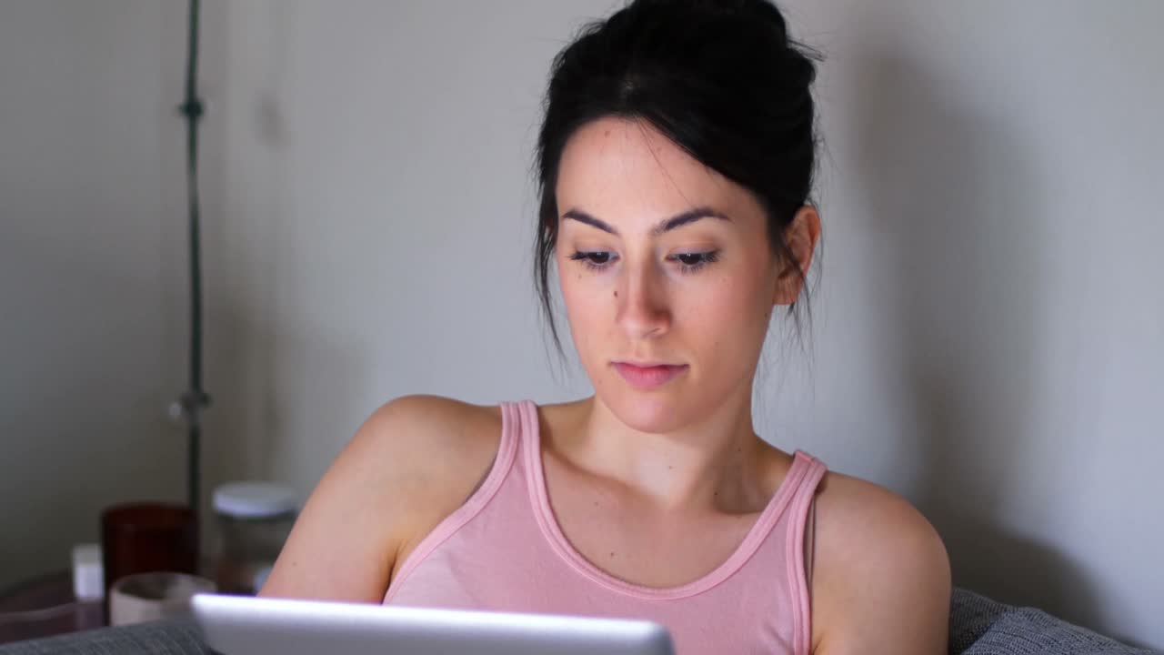 mujer usando tableta digital en el sofá en la sala de estar 4k