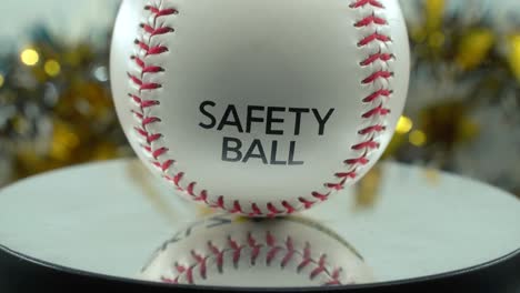 cinematic slow close-up shot of a white base ball, red stitches, safety ball, baseball on a shiny stand, christmas blurry decorations in the background, professional studio light, 4k video tilt up