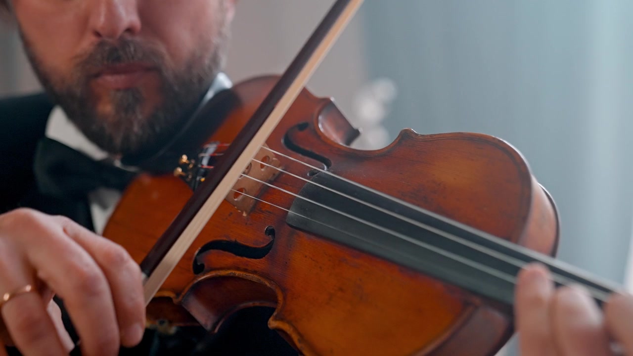 Primo piano di un uomo che suona il violino con l'archetto