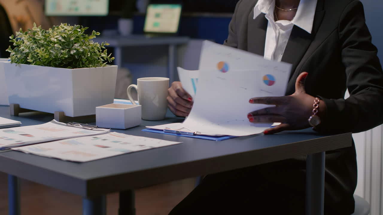 Group of diverse people working on design of building model with laptop and blueprints