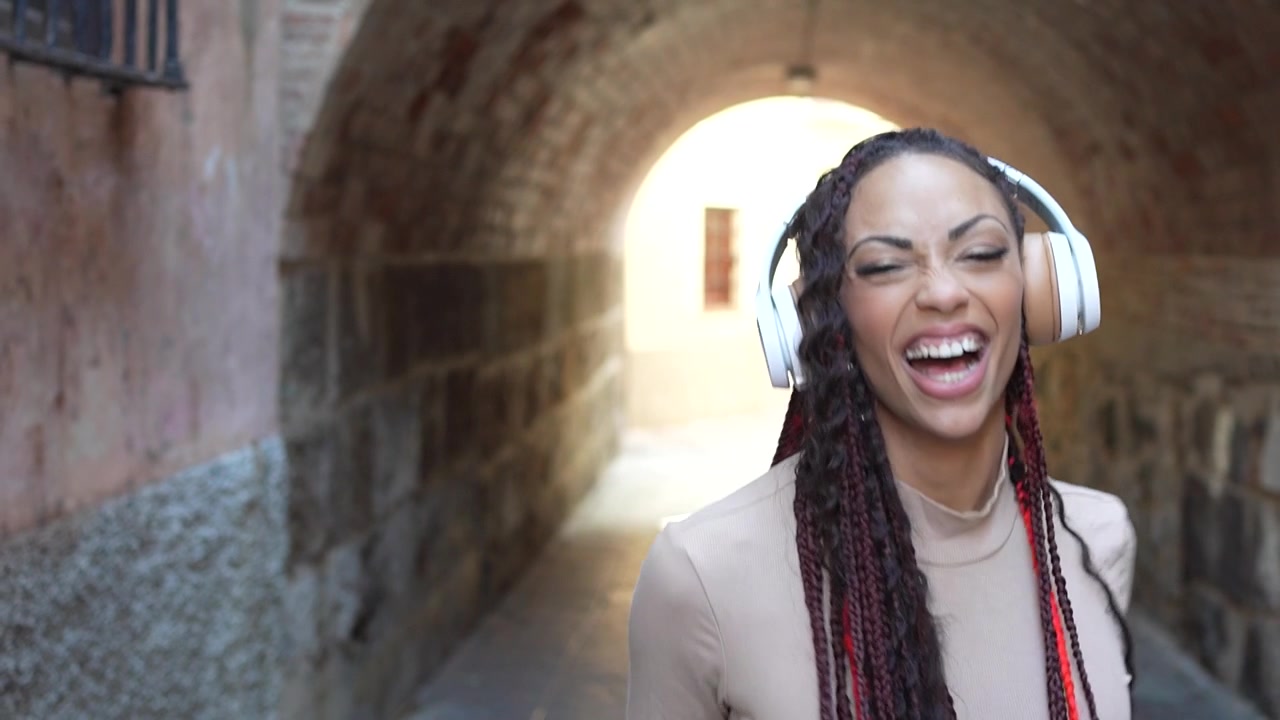 Una donna gioiosa che si gode felicemente la musica in un bellissimo arco inondato di sole.