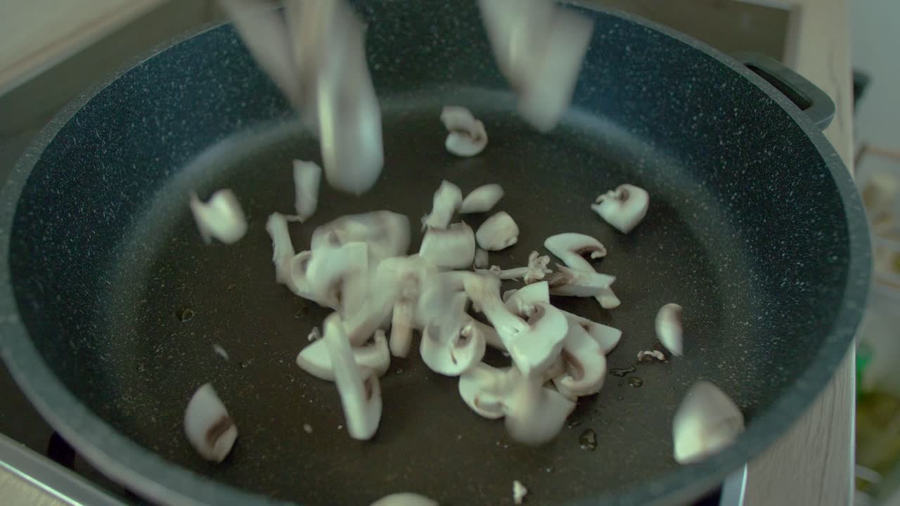 Mushrooms being thrown in pan in slow motion