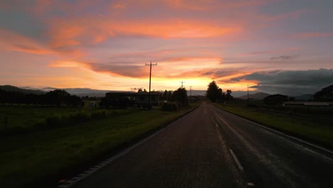 POV-Sicht-Autofahren-Entlang-Einer-Landstraße-Bei-Sonnenuntergang-In-Der-Abenddämmerung-In-4k-Uhd