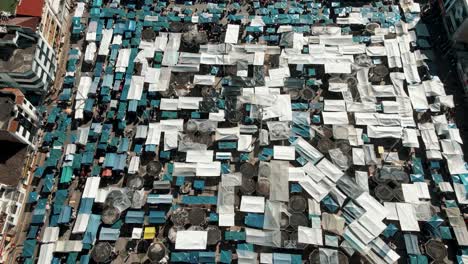 Panoramic-View-Over-Plaza-de-Ponchos-In-The-City-Of-Otavalo-In-Ecuador---drone-shot