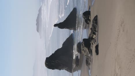 toma vertical de las columnas de roca en la playa de bandon en oregon.