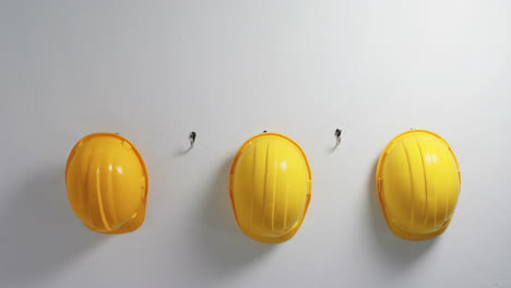 Hardhats-hanging-on-hook-wall-4k