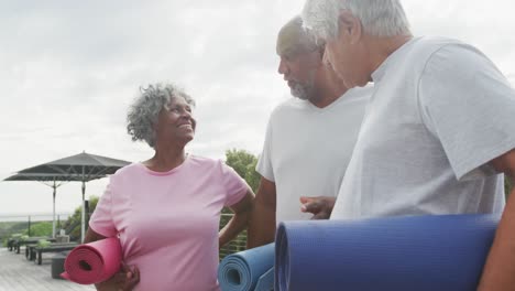 Happy-senior-diverse-people-practicing-yoga-in-garden-at-retirement-home