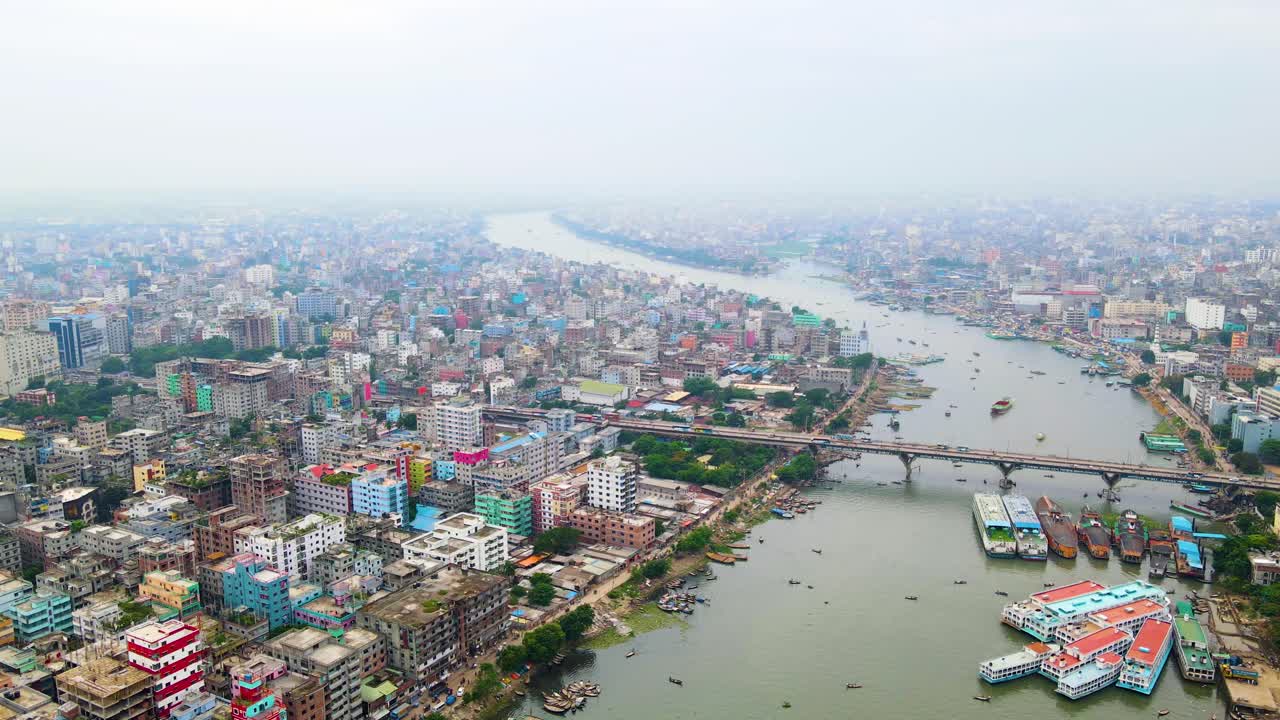Ripresa aerea discendente con drone di Dhaka, Bangladesh, con edifici e fiume con barca nel Buriganga