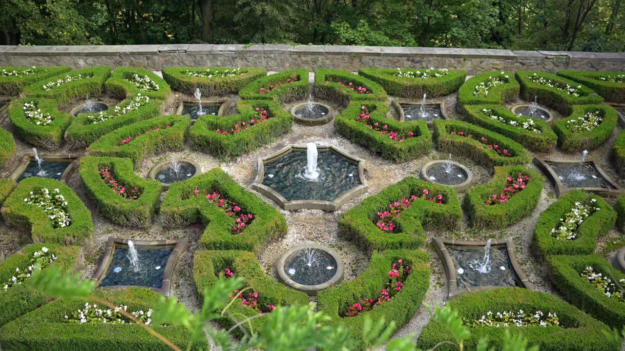 Fontes e sebes aparadas com flores nos jardins do Castelo de Książ, Polônia